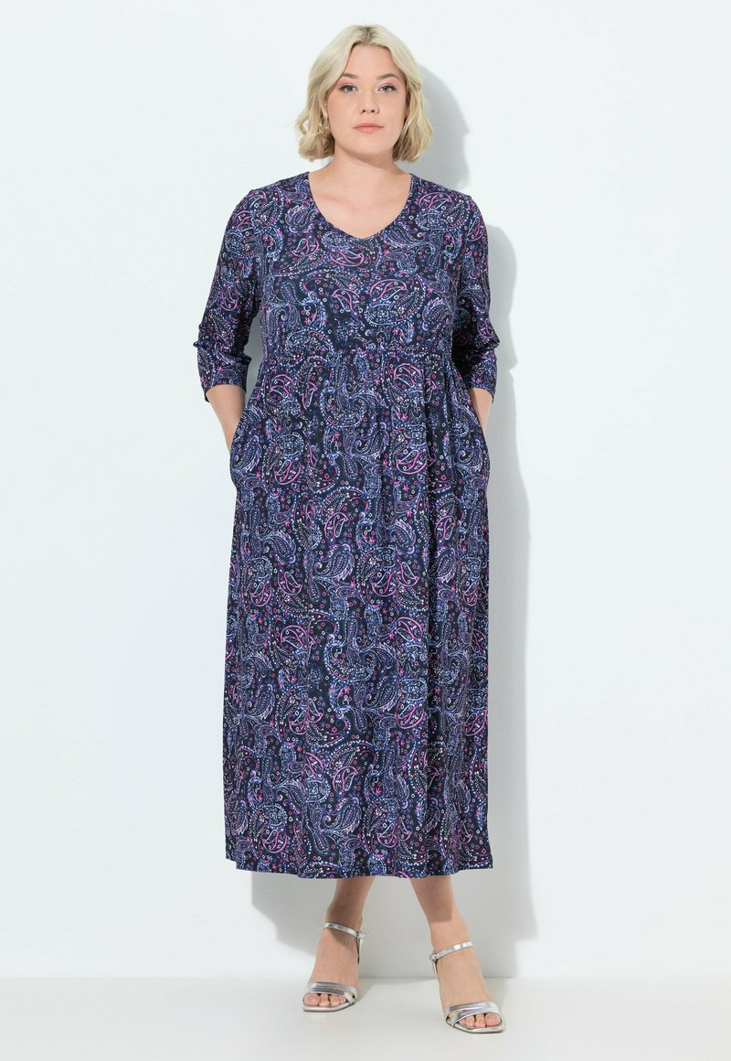 Vestido largo azul marino con un estampado de paisley en púrpura y rosa. Mangas tres cuartos, corte relajado y bolsillos en las caderas.