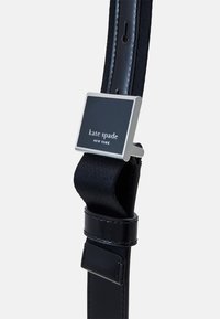 Cintura in tessuto nero con una fibbia in metallo lucido argentato. La fibbia presenta un design rettangolare e il nome del marchio in rilievo. Texture liscia.