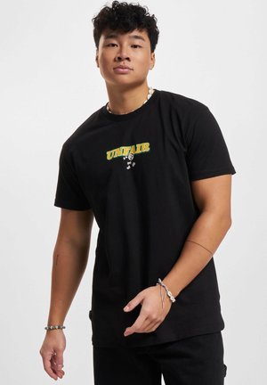 Czarny bawełniany t-shirt z napisem „UNFAIR” w kolorach zielonym i żółtym, o okrągłym dekolcie, z krótkimi rękawami i luźnym krojem.