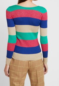 Sweter z dzianiny prążkowanej z długimi rękawami, ozdobiony poziomymi paskami w kolorach zielonym, czerwonym, niebieskim i beżowym, z delikatnym metalicznym połyskiem.