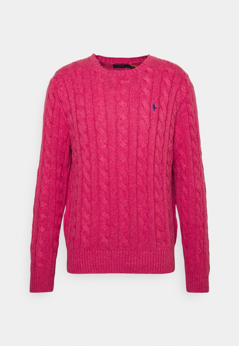 Pull rose en maille torsadée avec col rond, poignets et ourlet côtelés, arborant un petit logo bleu sur la poitrine. Texture douce.