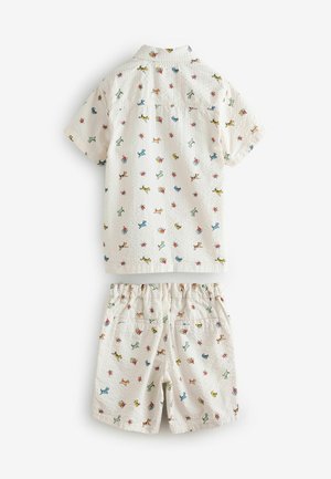 Kratkās piedurknes krekls un šortus komplekts baltā audumā, ar krāsainu mazu suņu un ziedu rakstu. Struktūrēts materiāls, elastīga josta.