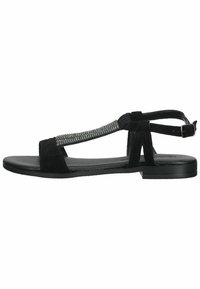 Black suede sandals with a flat sole, T-strap design, and embellished rhinestone detail along the front strap. Adjustable ankle buckle.