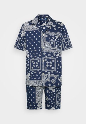 Conjunto de camisa de manga curta e calções em azul-marinho com padrões e detalhes em paisley brancos. Tecido de algodão com um corte descontraído e detalhes em botão.