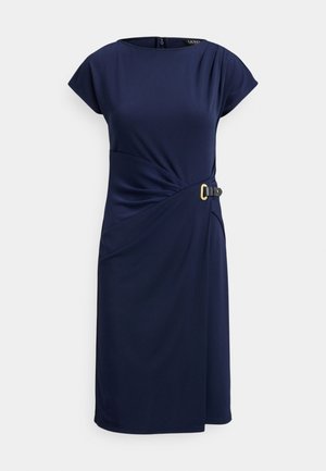Vestido azul-marinho em material liso com mangas curtas tipo capa e design torcido com fivela dourada de destaque na cintura. Fecho de correr nas costas.