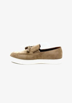 Chaussure slip-on en daim brun avec un bout arrondi, un détail de franges et une semelle en caoutchouc blanc, présentant des accents cousus et un design bas.