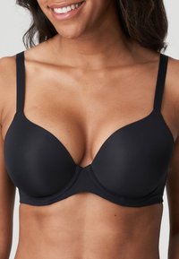 Czarny, wyściełany biustonosz z regulowanymi ramiączkami, gładką fakturą i dopasowanym krojem. Oferuje bezszwowe wykończenie oraz subtelne detale w szwie.