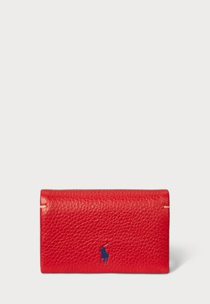 Red leather wallet with textured finish. Features a blue logo accent and gold-tone hardware. Compact, rectangular shape, fold-over design.