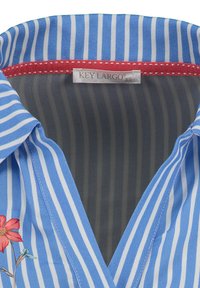 Blauw-wit gestreepte stoffen blouse met een rode rand bij de kraag, voorzien van een bloemmotief aan de linkerkant en een gladde textuur.