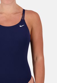 Navy blue swimsuit with a fitted design, thin straps, a round neckline, and a small white Nike logo on the upper left side.