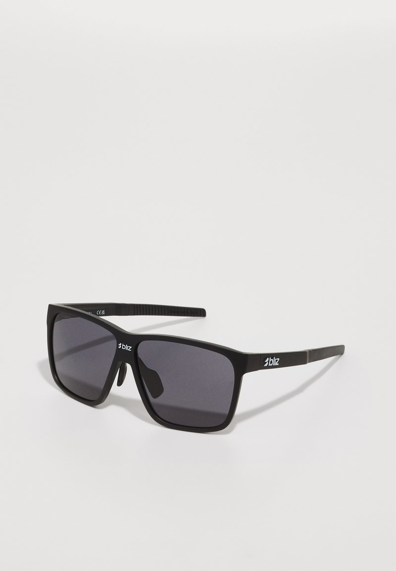 Schwarze Sonnenbrille mit quadratischem Rahmen, dunkeltönenden Gläsern und strukturierten Bügelakzenten. Logo an der Seite angebracht. Leichtes Kunststoffmaterial.