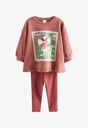 Top de manga larga en rosa polvo con estampado de hada y flores, combinado con leggings acanalados a juego, ambos con bordes con volantes.