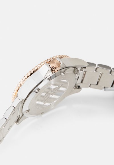 Edelstahl-Uhr mit einer Lünette und Krone aus Roségold. Verfügt über ein verlinktes Metallarmband und ein strukturiertes Gehäuseboden-Design.