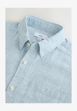Svetlo modra, tkana srajca z teksturiranim vzorcem, z ovratnikom na gumb, dvema sprednjima gumboma in prsno žepom, označena z velikostjo M.