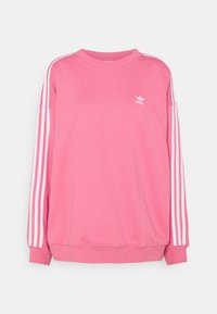 Rosa sweatshirt med långa ärmar, ribbad halsringning och vita tresträcksdetaljer längs axlarna. Litet vitt logotyp på bröstet.