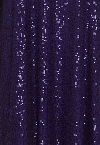 Tissu bleu foncé densément recouvert de petits sequins brillants réfléchissant la lumière en motifs verticaux dispersés.