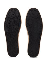 Sole in gomma nera con un motivo testurizzato e bordatura marrone chiaro, caratterizzata da un design a logo circolare su tutta la superficie.