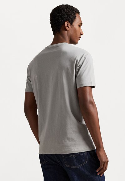 Γκρι κοντομάνικο μπλουζάκι από βαμβάκι με στρογγυλή λαιμόκοψη και άνετη εφαρμογή. Η πλάτη είναι απλή, χωρίς ορατά λογότυπα ή σχέδια.