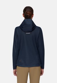 Marineblaue Softshelljacke mit Kapuze, strukturiertem Stoff und kontrastierendem Logo auf der Rückseite. Verfügt über seitliche Schlitze und eine lockere Passform.