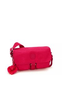 Rosa tygaxelväska med flapplock, justerbar rem och en nyckelringsberlock med ett fluffigt djur. Enkel och funktionell design.