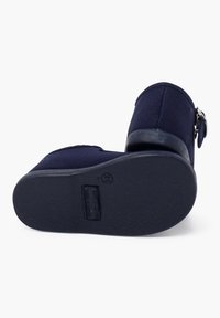Zapatos de lona navy con suela texturizada, punta redondeada, detalle de hebilla lateral y talón reforzado. Suela plana de goma para mejor agarre.