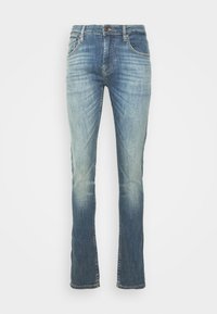 Vaqueros de mezclilla en azul medio con un lavado desgastado. Presentan bragueta con botones, cinco bolsillos y un diseño de pierna recta con un ligero deshilachado en el dobladillo.