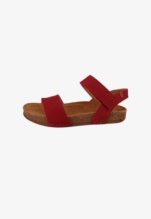 Rød sandal med åben tå, justerbare stropper ved ankel og tå, korksål og en blød brun fodseng.