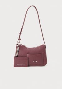 Sac à main en cuir bordeaux avec une forme structurée, fermeture éclair argentée, poche avant et porte-cartes détachable. Présente des accents de logo.