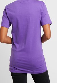 Kort lila bomulls t-shirt med korta ärmar, rundad halsringning och en mjuk textur. Har en enkel design utan några mönster eller detaljer.