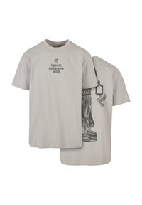 Light gray cotton t-shirt featuring front text "innocent until proven guilty" and a black graphic of a statue with a lantern on the back.