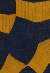 Calze a righe nei colori blu navy e giallo senape. Tessuto a maglia con texture a coste. Particolari righe larghe alternate e tallone a contrasto.