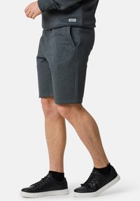 Szare szorty z mieszanki bawełny z bocznymi kieszeniami, elastycznym pasem i przeszywanym wykończeniem; zestawione z czarnymi trampkami i skarpetkami do kostek.