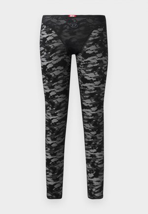 Leggings noirs avec une superposition en dentelle texturée présentant un motif camouflage gris. Taille élastique avec un petit logo à l'avant.