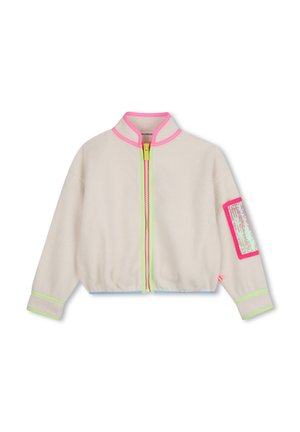 Veste polaire couleur crème avec bordure de col rose, contour de fermeture éclair vert néon, ourlet bleu et un patch rose avec des sequins sur la manche gauche.