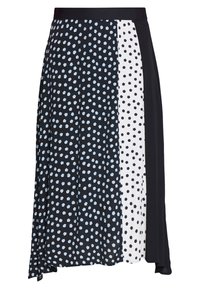 Falda hasta la rodilla con paneles en blanco y negro, con patrones hexagonales azul claro en un lado y negro sólido en el otro. Textura suave.