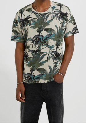 T-shirt med korte ærmer i lysebeige med mønster af grønne og blå palmeblade. Fremstillet af bomuld med rund halsudskæring og afslappet pasform.