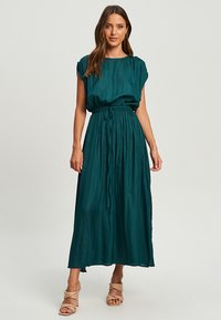 Teal, sleeveless maxi dress with gathered waist and drawstring detailing. Soft, smooth fabric with a flowy silhouette.