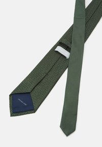 Cravate à motifs verts avec un design texturé, présentant une section verte unie et un intérieur bleu marine portant l'étiquette "Michael Kors".