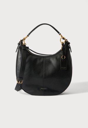 Black leather shoulder bag with gold hardware, adjustable strap, and brand tag on a light background.