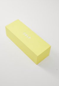 Boîte rectangulaire jaune avec une finition mate. Présente un texte blanc en relief "CDLP" sur le dessus. Texture lisse, sans motifs ni matériel visible.