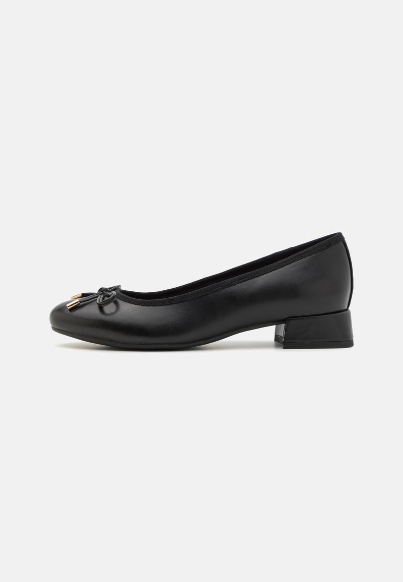 Ballerines en cuir noir avec un bout rond, un petit talon carré et un nœud décoratif avec des accents en ton doré à l'avant.