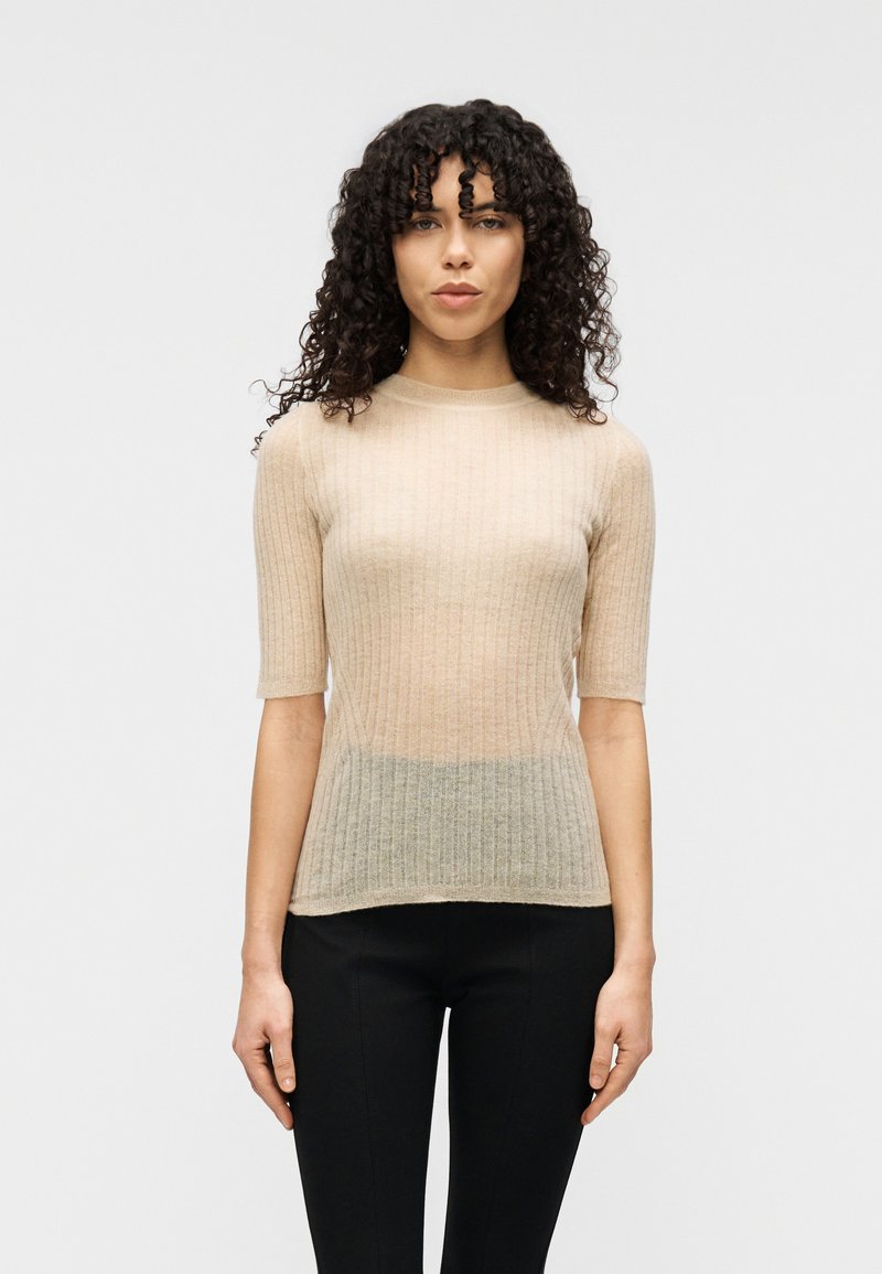 Ελαφρύ ριμπ πλεκτό τοπ με στρογγυλή λαιμόκοψη και κοντά μανίκια, σε μετάβαση από μπεζ σε ανοιχτό πράσινο στο τελείωμα.