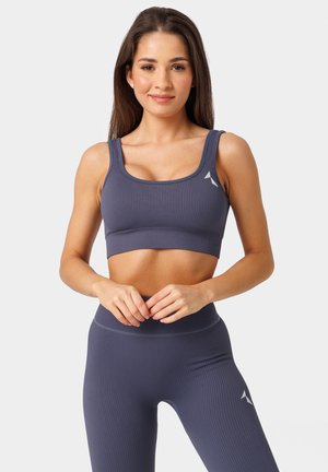 Ribbed, granatowy stanik sportowy z szerokimi ramiączkami i prostokątnym krojem. Posiada małe białe logo po lewej stronie, oferując dopasowany fason.