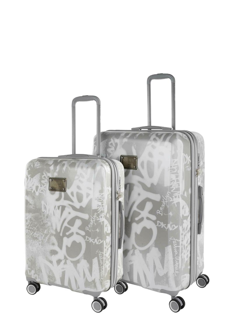 Dos maletas rígidas en gris claro con patrones de graffiti blancos. Disponen de asas retráctiles y cuatro ruedas para facilitar su movilidad.
