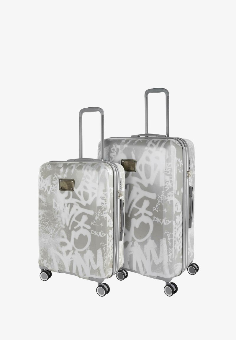 Dos maletas rígidas en gris claro con patrones de graffiti blancos. Disponen de asas retráctiles y cuatro ruedas para facilitar su movilidad.