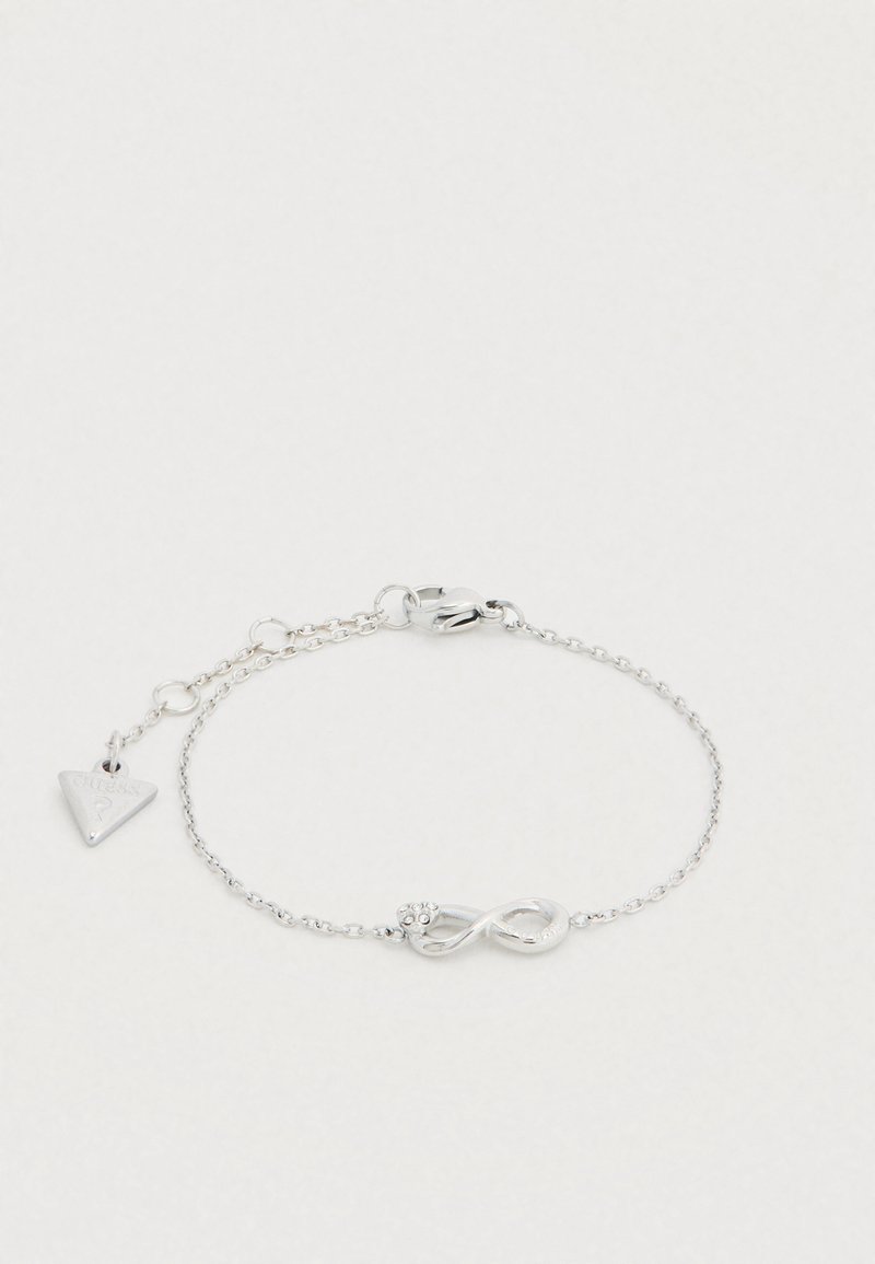 Le bracelet chaîne argentée présente un symbole d'infini avec un accent floral. Comprend un petit pendentif triangulaire avec le logo de la marque.