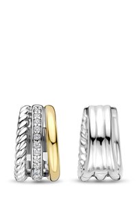 Zwei Ringe nebeneinander: einer mit einem gedrehten Silberdesign und der andere mit einer glatten Silberoberfläche und goldenen Akzenten, versehen mit klaren Steinverzierungen.