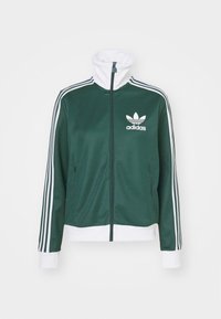 Mörkgrön Adidas träningsjacka med vita ränder på ärmarna, vit krage, muddar och fåll, framdragkedja och logotyp på vänster bröst.