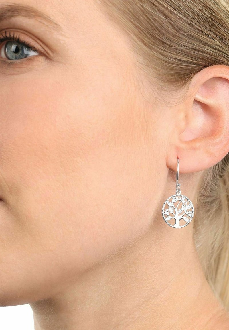 Pendientes de árbol de la vida de plata con un intrincado diseño recortado, forma circular y un delicado cierre de gancho. Acabado brillante y pulido.