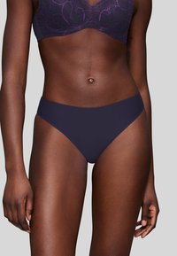 Tanga blu navy realizzato in tessuto liscio con copertura minima, dotato di una fascia in vita senza cuciture e senza motivi o accessori visibili.
